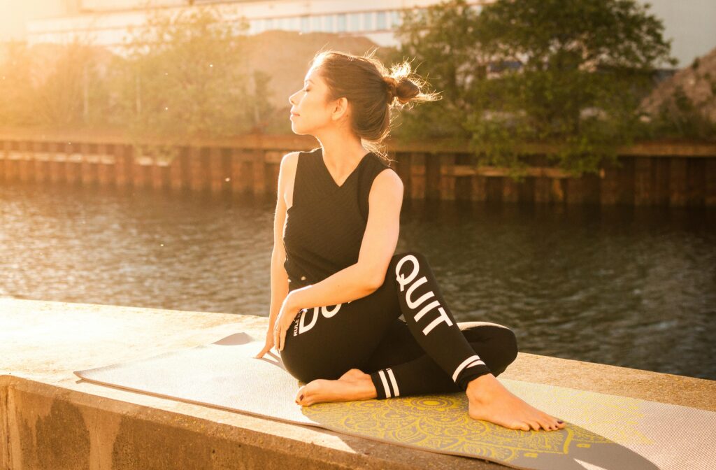 Person doing Yoga pose with the word Quit on her leggings